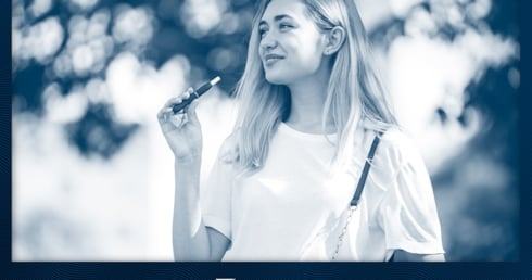 Eine Frau raucht eine Vape im Park
