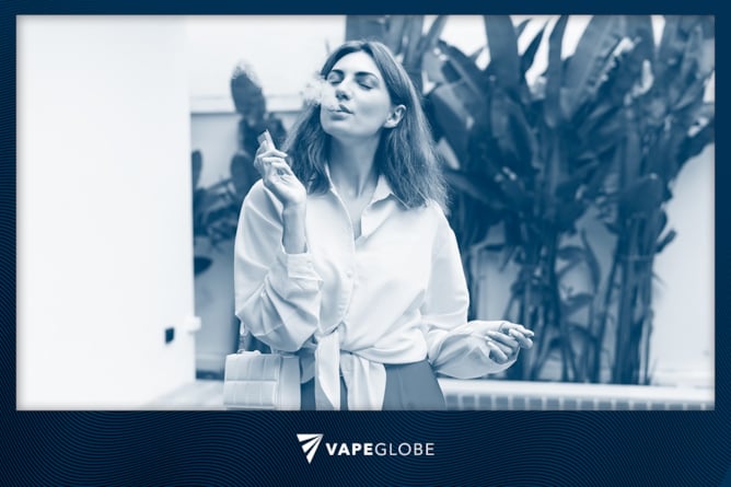 Frau vapt in sommerlicher Umgebung