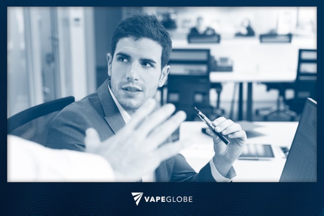 Mann am Arbeitsplatz mit einer E-Zigarette