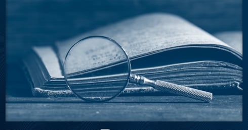 Buch und Lupe um das Thema Geschichte des Dampfens zu illustrieren