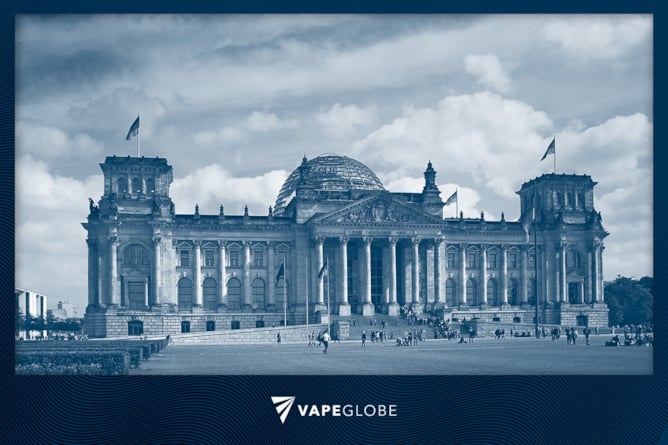 Der deutsche Bundestag mit Menschen auf der Wiese davor. 